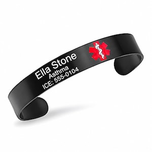 May include: A black cuff medical alert bracelet featuring a red Star of Life symbol with a white serpent and staff. The bracelet is engraved with the text Ella Stone, Asthma, and ICE: 555-0104 in white lettering on the front surface.