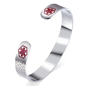 May include: A silver medical alert cuff bracelet. The bracelet has a red medical symbol on each end. The ends are hexagonal. The sides of the bracelet have a textured pattern.