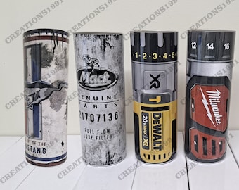 May include: Four different designs of stainless steel tumblers. The first tumbler has a blue and white design with the words "Art of the Mustang". The second tumbler has a black and white design with the words "Mack Genuine Parts 21707136 Full Flow Lube Filter". The third tumbler has a black and yellow design with the words "Dewalt XR 20Vmax/XR 1-2-3-4-5". The fourth tumbler has a red, black, and gray design with the words "Milwaukee 12 14 16".