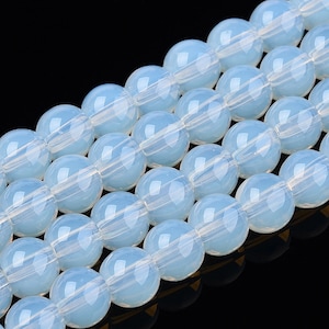May include: A strand of light blue glass beads. The beads are round and have a smooth, polished finish.