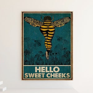 Può includere: Un poster incorniciato con un'illustrazione stravagante di un'ape con una forma umana. L'ape ha strisce gialle e nere, con ali a motivi floreali. Il testo "HELLO SWEET CHEEKS" è visualizzato nella parte inferiore del poster.