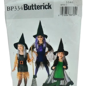 以下が含まれることがあります： 3人の子供の魔女の衣装が描かれた、Butterickの裁縫パターンパッケージ。衣装には、黒い尖った帽子、ドレス、ケープが含まれています。パッケージには「BP334 Butterick」というテキストとバーコードが付いています。