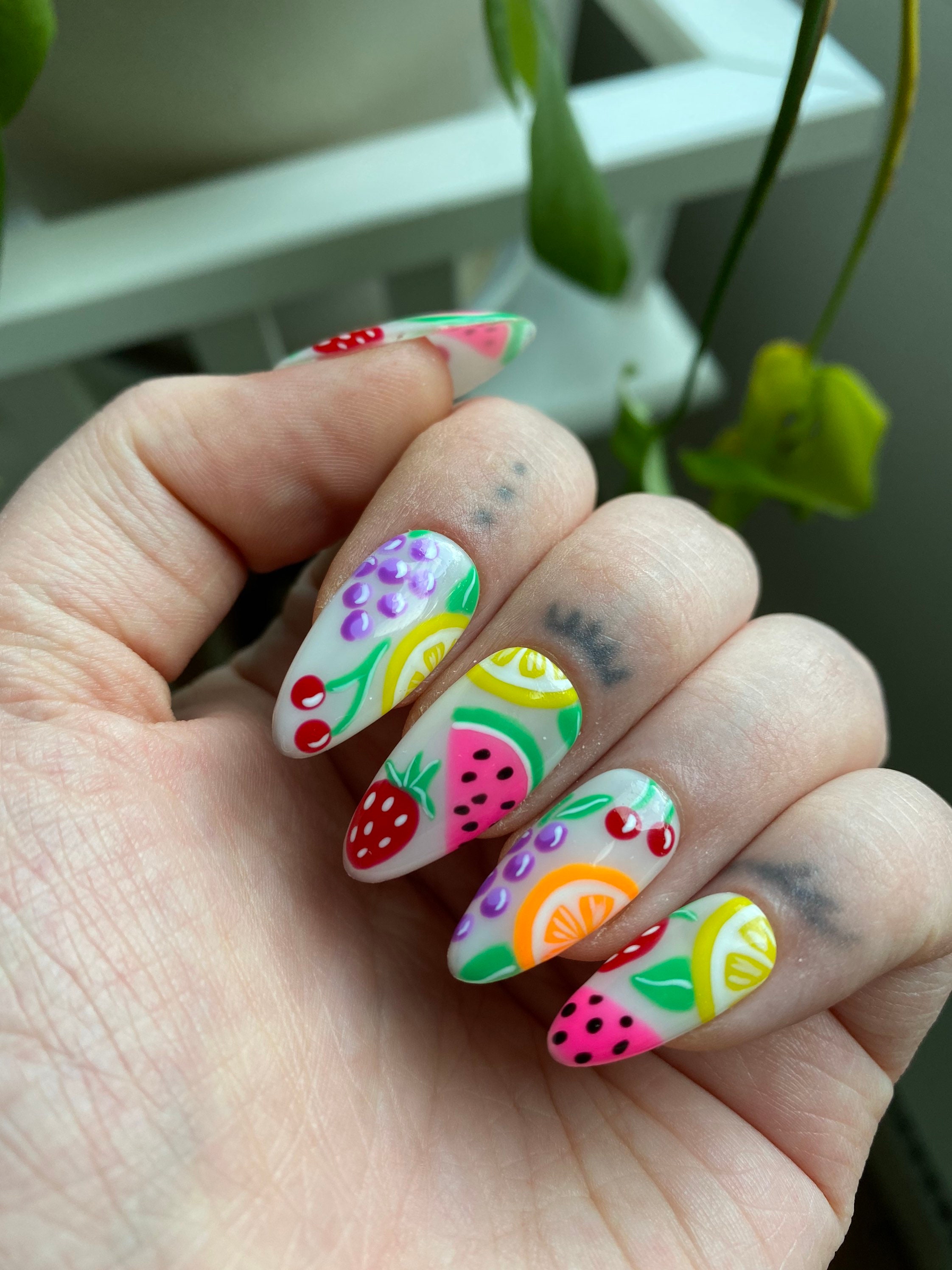Nail art featuring watermelon, pineapple and other tropical fruits