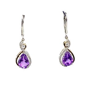 Puede incluir: Un par de pendientes de plata con una piedra preciosa de amatista en forma de pera y un pequeño acento de diamante. Los pendientes tienen un diseño retorcido y un cierre de palanca.