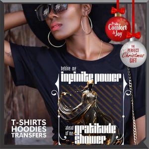 Może przedstawiać: Czarny t-shirt z graficznym wzorem z napisami "infinite power" i "gratitude shower". Projekt zawiera ilustrację postaci w powł&oacute;czystej sukni. Koszulka zawiera r&oacute;wnież napis "T-SHIRTS HOODIES TRANSFERS".