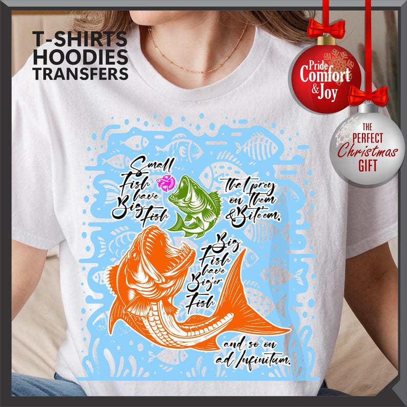 Pu&ograve; includere: T-shirt bianca con una grafica di pesce colorata e il testo "Small fish have big fish" e "Big fish have bigger fish". La maglietta ha anche il testo "and so on ad infinitum".