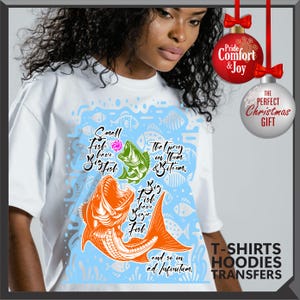 Pu&ograve; includere: T-shirt bianca con una grafica di pesce colorata e il testo "Small Fish have Big Fish, The prey on them & bite 'em, Big Fish have Bigger Fish, and so on ad infinitum." La maglietta ha anche il testo "T-SHIRTS HOODIES TRANSFERS."