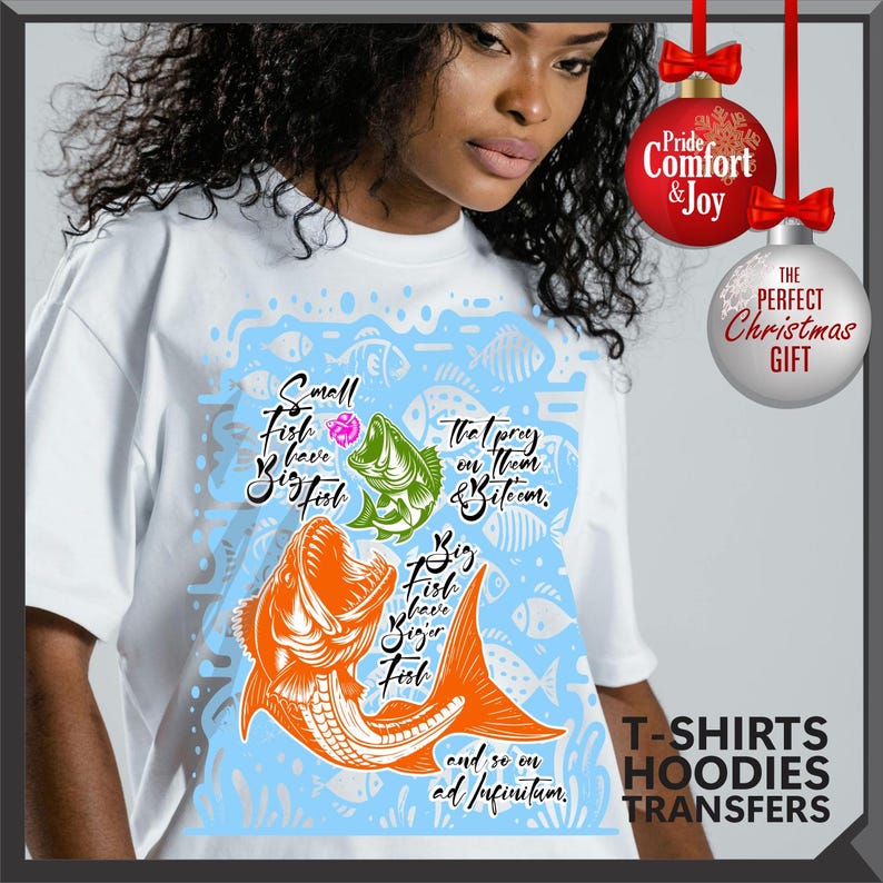 Pu&ograve; includere: T-shirt bianca con una grafica di pesce colorata e il testo "Small Fish have Big Fish, The prey on them & bite 'em, Big Fish have Bigger Fish, and so on ad infinitum." La maglietta ha anche il testo "T-SHIRTS HOODIES TRANSFERS."