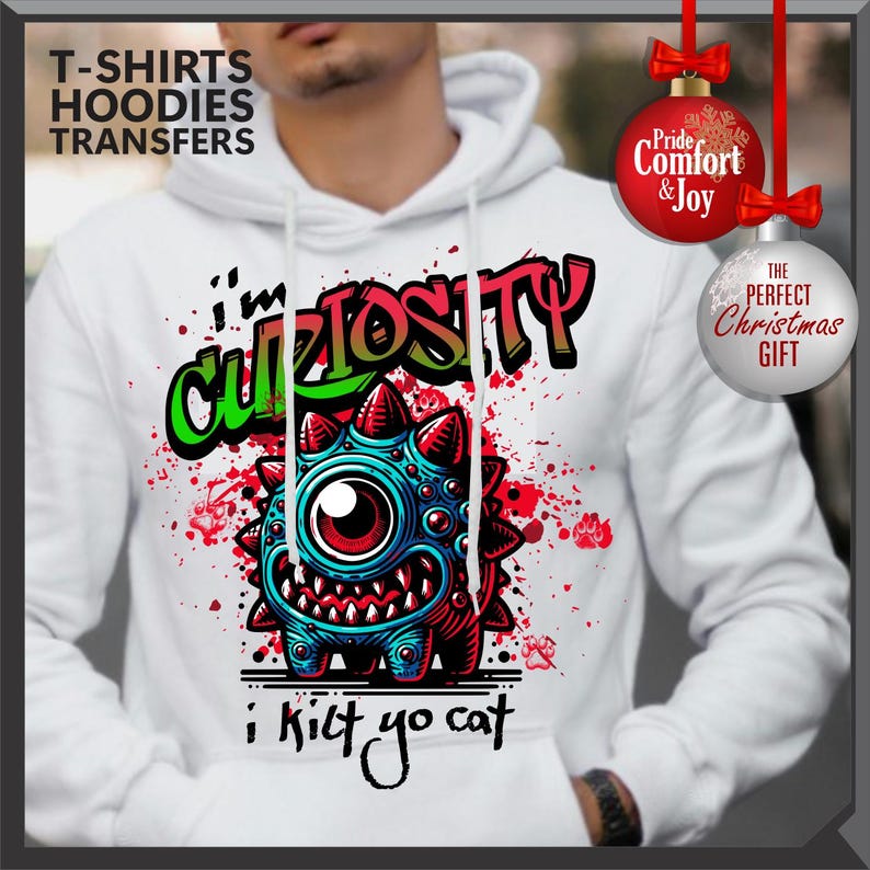 Może przedstawiać: Biała bluza z kapturem z grafiką z kresk&oacute;wkowym potworem z napisem "I'm Curiosity" i "i kilt yo cat". Projekt wykorzystuje kolory czerwony, niebieski i zielony. Bluza ma kaptur ze sznurkiem i długie rękawy. Widoczne są r&oacute;wnież ozdoby świąteczne.