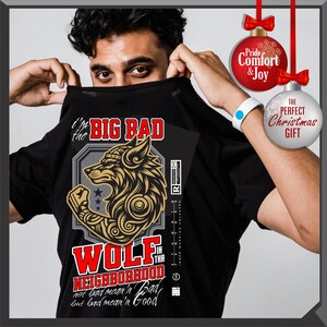 Puede incluir: Camiseta negra con un dise&ntilde;o de lobo dorado y negro y el texto "I'm the Big Bad Wolf in the Neighborhood". La camiseta tambi&eacute;n tiene el texto "not bad mean'n' Bad, but bad mean'n' Good".