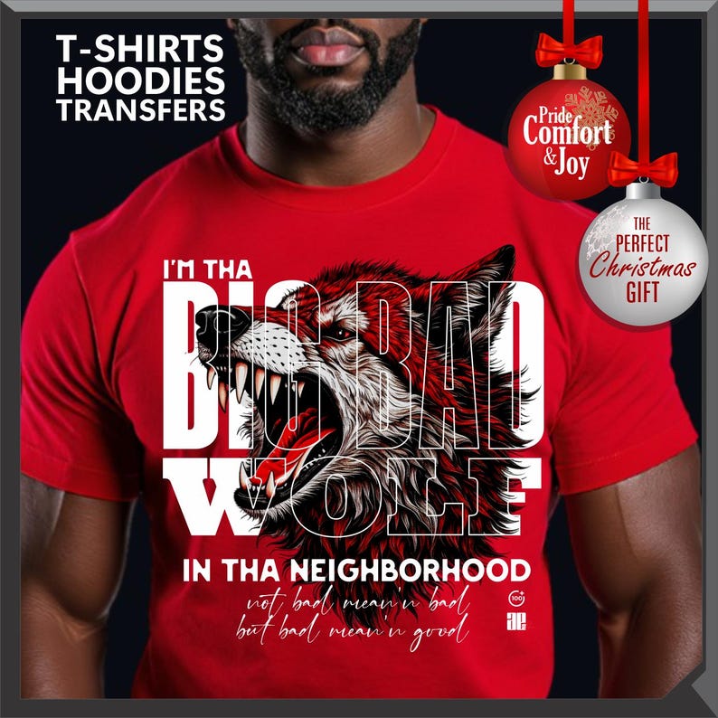 Op de afbeelding: Rood t-shirt met een afbeelding van een grommende wolf en de tekst "I'M THA BIG BAD WOLF IN THA NEIGHBORHOOD". Het shirt heeft ook de tekst "not bad mean'n bad but bad mean'n good". De afbeelding bevat kerstversieringen.