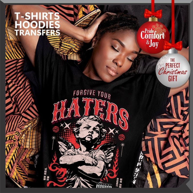 May include: Black t-shirt with the text "FORGIVE YOUR HATERS" in red and white, featuring an angel graphic. The image includes text that says "T-SHIRTS HOODIES TRANSFERS". Decorative Christmas ornaments with text are also present.