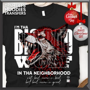 Op de afbeelding: Zwart T-shirt met een rode en witte wolfsgrafiek en de tekst "I'M THA BIG BAD WOLF IN THA NEIGHBORHOOD". Het shirt heeft ook de tekst "not bad mean'n bad but bad mean'n good".