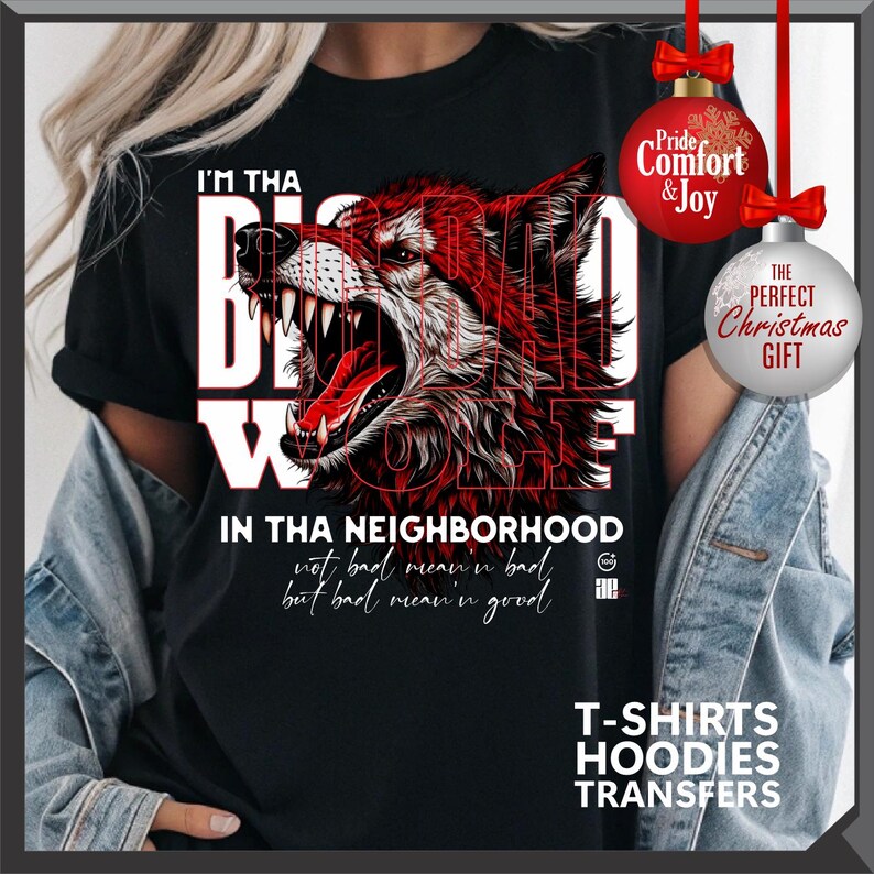 Op de afbeelding: Zwart T-shirt met een rode en witte afbeelding van een grommende wolf. De tekst op het shirt luidt "I'M THA BIG BAD WOLF IN THA NEIGHBORHOOD" en "not bad mean'n bad but bad mean'n good". Bevat de tekst "T-SHIRTS HOODIES TRANSFERS".