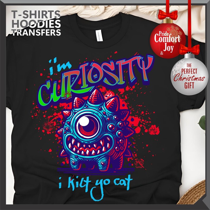 Może przedstawiać: Czarny t-shirt z kolorową grafiką potwora i napisem "i'm CURIOSITY i kilt yo cat". Potw&oacute;r jest niebieski z czerwonymi kolcami i dużym okiem. Koszulka ma r&oacute;wnież napis "T-SHIRTS HOODIES TRANSFERS".