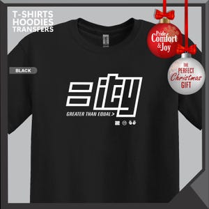 May include: Black t-shirt with a white graphic that reads "eity" and "GREATER THAN EQUAL >". The shirt also has the text "T-SHIRTS HOODIES TRANSFERS" at the top. The image includes Christmas ornaments that say "Pride & Joy" and "THE PERFECT Christmas GIFT".