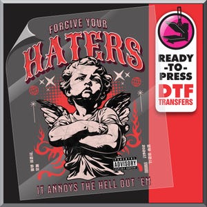 May include: DTF transfer sheet with a graphic of an angel with crossed arms, wings, and the text "FORGIVE YOUR HATERS" in red. Below, it reads "IT ANNOYS THE HELL OUT 'EM". A "READY-TO-PRESS DTF TRANSFERS" label is on the right.