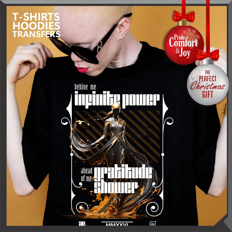 Może przedstawiać: Czarny t-shirt z graficznym wzorem z napisami "infinite power" i "gratitude shower". Projekt zawiera złoto-czarną ilustrację postaci. Koszulka ma r&oacute;wnież napis "T-SHIRTS HOODIES TRANSFERS".