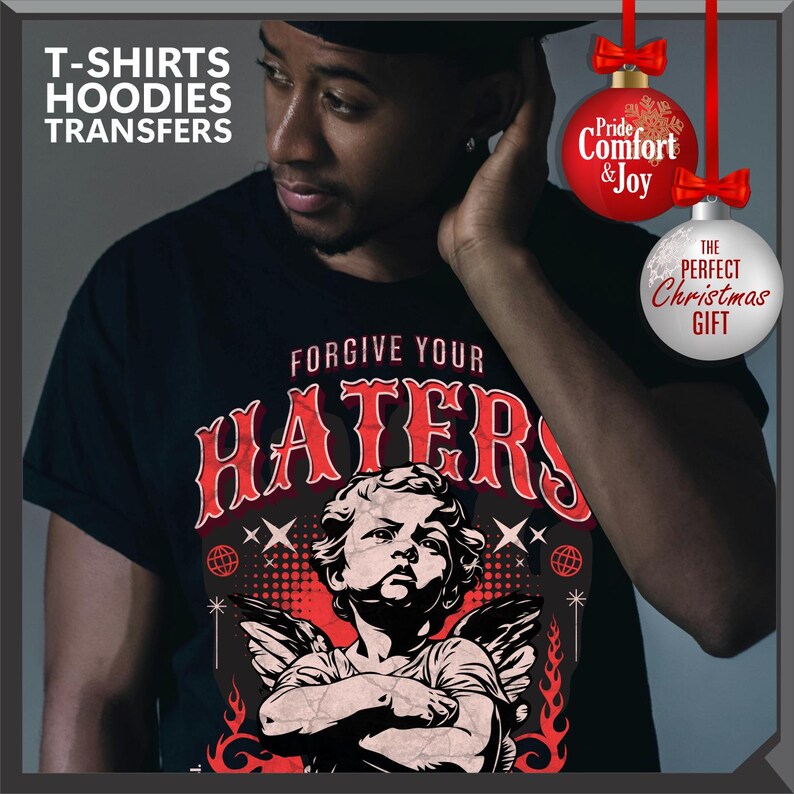 May include: Black t-shirt with the text "FORGIVE YOUR HATERS" in red, featuring an illustration of an angel. The image also includes the text "T-SHIRTS HOODIES TRANSFERS". Decorative Christmas ornaments with text are also visible.