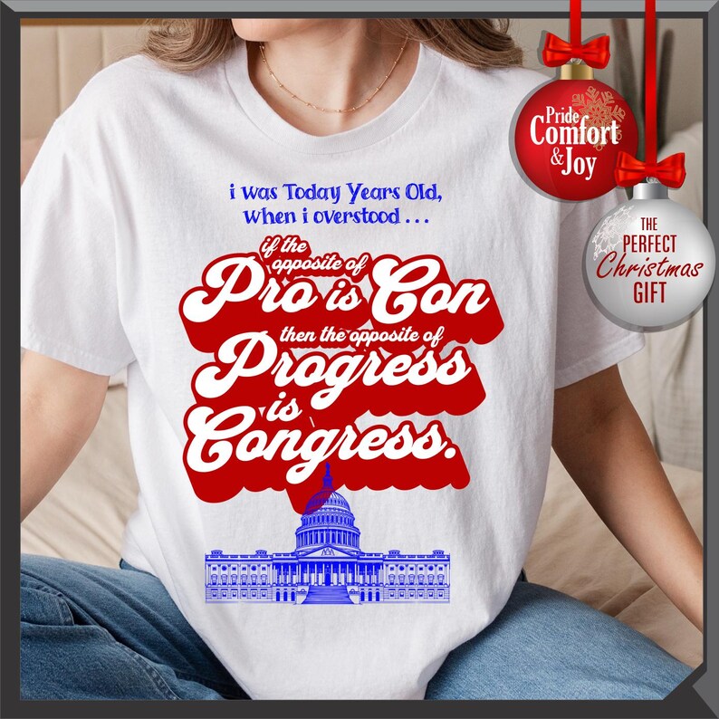 May include: White t-shirt with a political statement in red and blue. The text reads "i was Today Years Old, when i overstood... if the opposite of Pro is Con then the opposite of Progress is Congress." A Capitol building graphic is at the bottom.