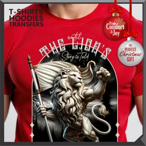 May include: Red t-shirt with a lion illustration holding a flag, and the text "The Lion's Story is Told." The design also includes the phrases "Pride, Comfort & Joy" and "The Perfect Christmas Gift."