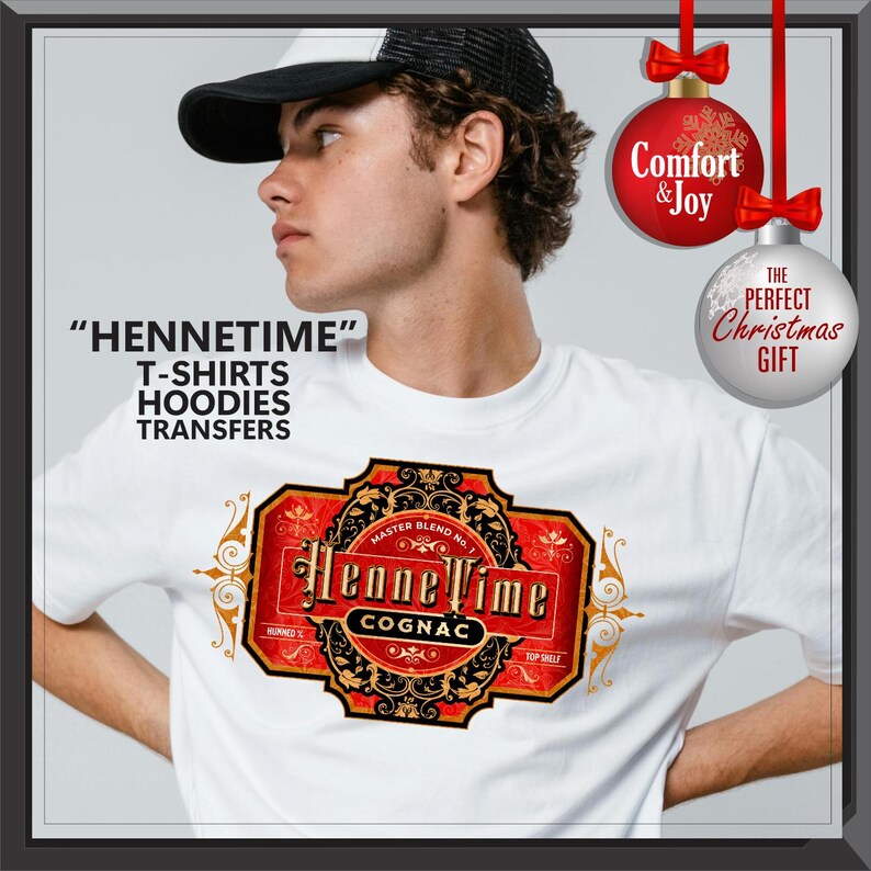 May include: White t-shirt with a cognac label design. The label is red and gold with the words "HenneTime Cognac". The image also includes the text "T-shirts, Hoodies, Transfers". Two Christmas ornaments are in the background.