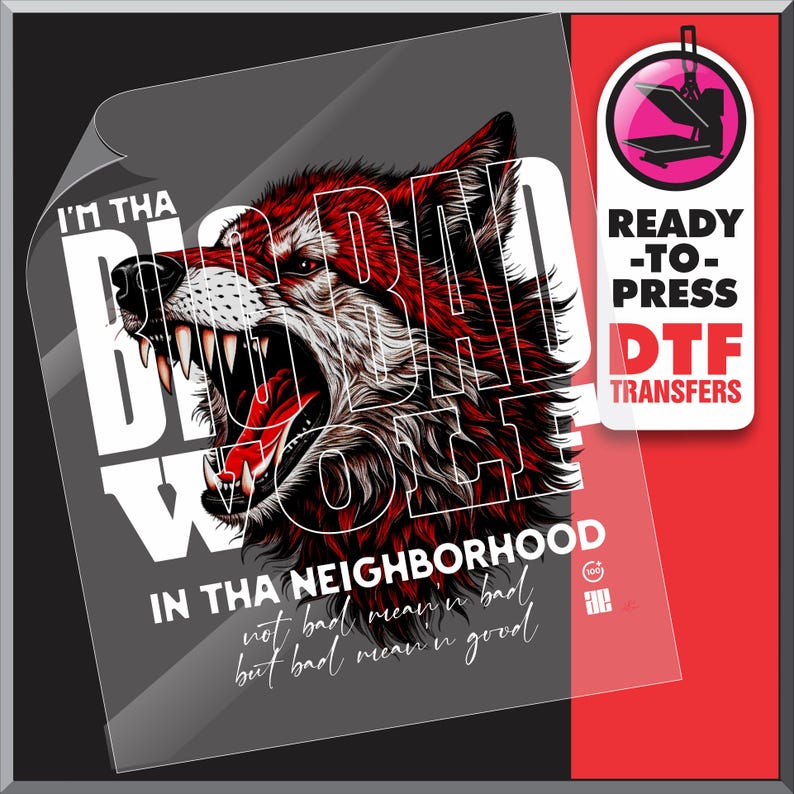 Op de afbeelding: Een DTF-transfer met een grommende wolf met rode en witte vacht, en de tekst "I'M THA BAD WOLF IN THA NEIGHBORHOOD". Het ontwerp bevat de zin "not bad mean'n bad but bad mean'n good". Een label "Ready-to-Press DTF Transfers" is ook zichtbaar.