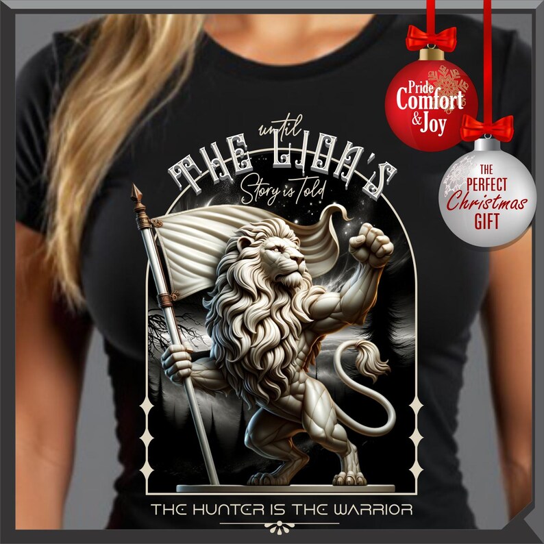 May include: Black t-shirt with a detailed lion illustration holding a flag. Text includes "THE LION'S Story is told" and "THE HUNTER IS THE WARRIOR". Features Christmas ornament graphics with "Pride Comfort & Joy" and "THE PERFECT Christmas GIFT".