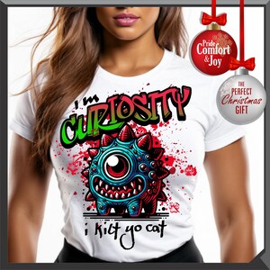 Może przedstawiać: Biała koszulka z motywem potwora z kresk&oacute;wki. Potw&oacute;r jest niebiesko-czerwony z jednym okiem i kolcami. Koszulka ma napis "I'm Curiosity" w stylu graffiti i "i kilt yo cat". Czerwone i zielone akcenty.