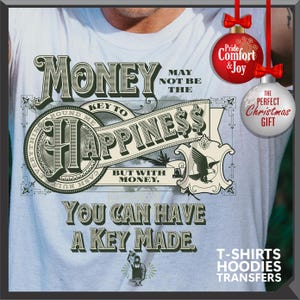 Pu&ograve; includere: Maglietta azzurra con un design grafico a forma di banconota, con le parole "Money" e "Happiness". Il design include un'aquila e il testo "You Can Have A Key Made". Ornamenti natalizi decorativi sullo sfondo.
