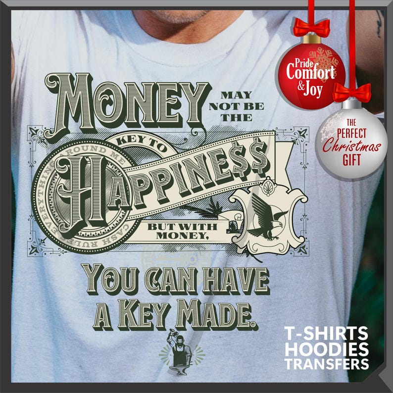 Pu&ograve; includere: Maglietta azzurra con un design grafico a forma di banconota, con le parole "Money" e "Happiness". Il design include un'aquila e il testo "You Can Have A Key Made". Ornamenti natalizi decorativi sullo sfondo.
