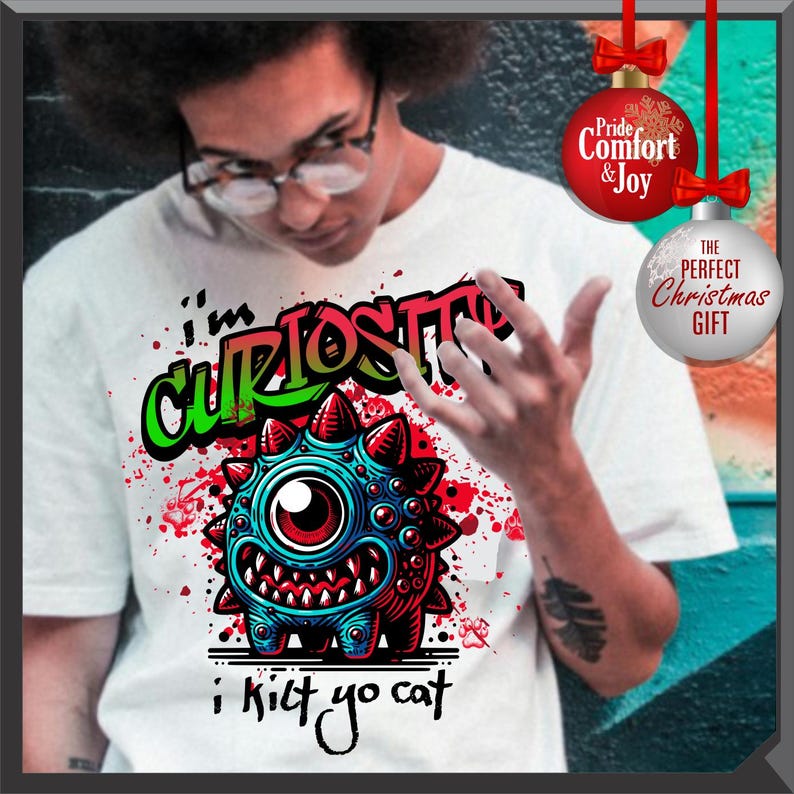Może przedstawiać: Biała koszulka z kolorową grafiką jednookiego potwora i napisem "i'm CURIOUS i kilt yo cat". Projekt zawiera kolory czerwony, niebieski i zielony. Koszulka to element odzieży codziennej.