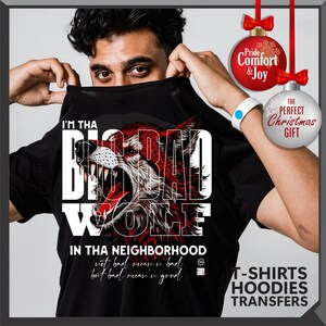Op de afbeelding: Zwart T-shirt met een rode en witte wolfafbeelding en de tekst "I'M THA BIG BAD WOLF" en "IN THA NEIGHBORHOOD". Het shirt heeft ook de tekst "not bad mean'n bad but bad mean'n good".