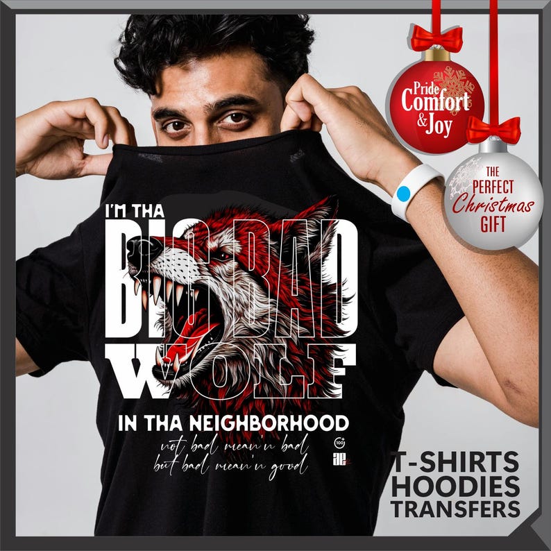 Op de afbeelding: Zwart T-shirt met een rode en witte wolfafbeelding en de tekst "I'M THA BIG BAD WOLF" en "IN THA NEIGHBORHOOD". Het shirt heeft ook de tekst "not bad mean'n bad but bad mean'n good".