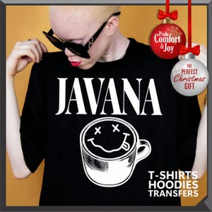 以下が含まれることがあります： 白い文字で「JAVANA」と書かれた黒いTシャツ。スマイリーフェイスのコーヒーカップのデザインが上にあります。画像には「T-SHIRTS HOODIES TRANSFERS」というテキストが含まれています。背景には2つのクリスマスオーナメントがあります。