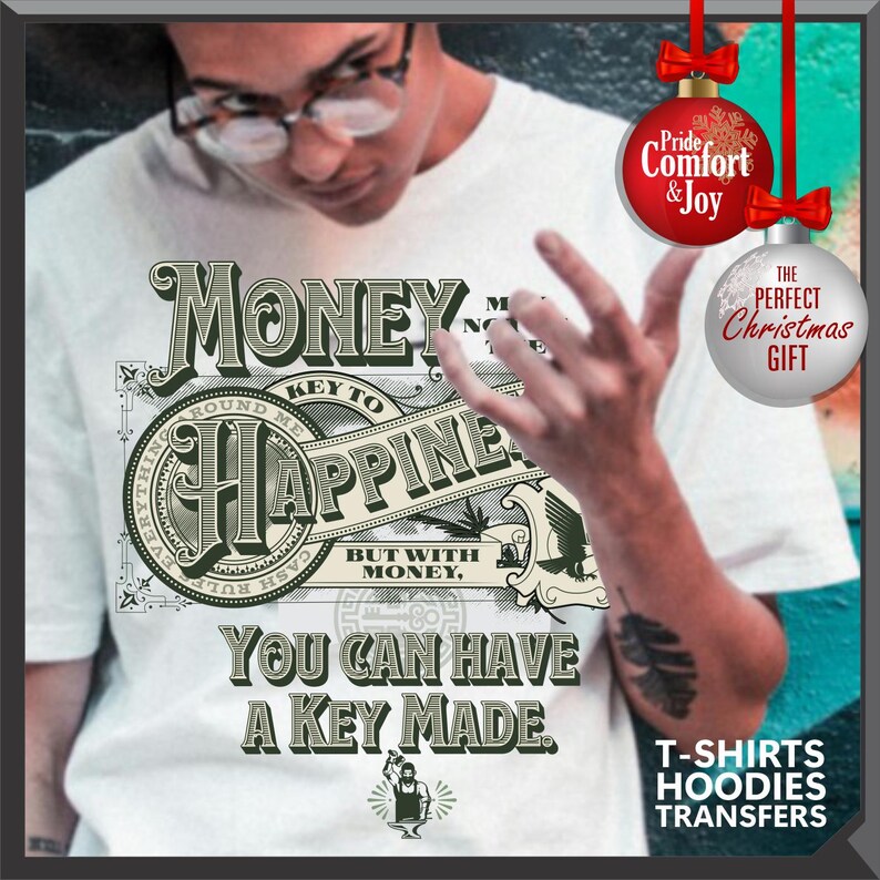 Pu&ograve; includere: T-shirt bianca con un design grafico con la parola "MONEY" e la frase "KEY TO HAPPINESS". Il design include il testo "YOU CAN HAVE A KEY MADE". La maglietta ha anche una piccola illustrazione di una persona che lavora.