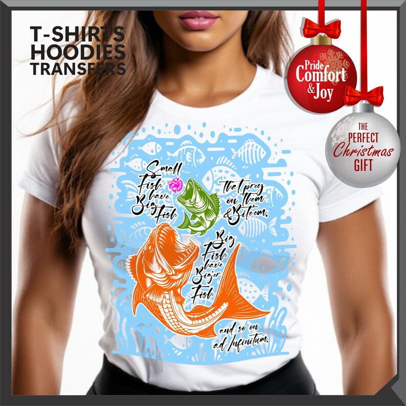 Pu&ograve; includere: T-shirt bianca con una grafica di pesce colorata e il testo "Small Fish have Big Fish" e "Big Fish have Bigger Fish". Il design include illustrazioni di pesci arancioni, verdi e blu. La maglietta ha anche il testo "The prey on them & bite 'em" e "and so on ad infinitum."