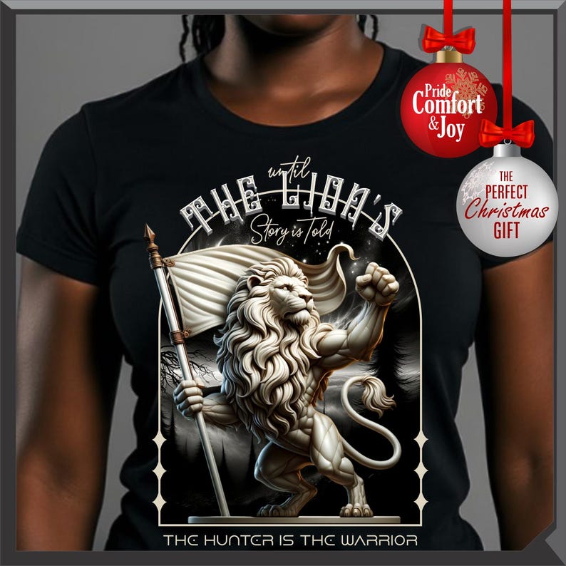 May include: Black t-shirt with a detailed illustration of a lion holding a flag, with the text "THE LION'S Story is Told" and "THE HUNTER IS THE WARRIOR". The design is in a white and grey colour scheme.
