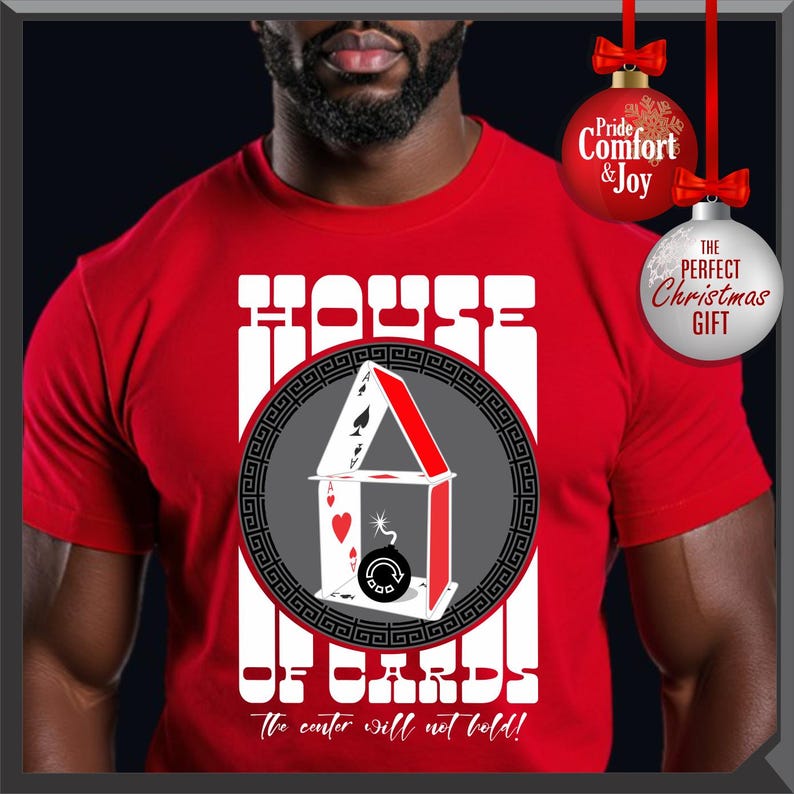 May include: Red t-shirt with a graphic of a house of cards design. The design includes playing cards, a bomb, and the text "HOUSE OF CARDS" and "The center will not hold!"