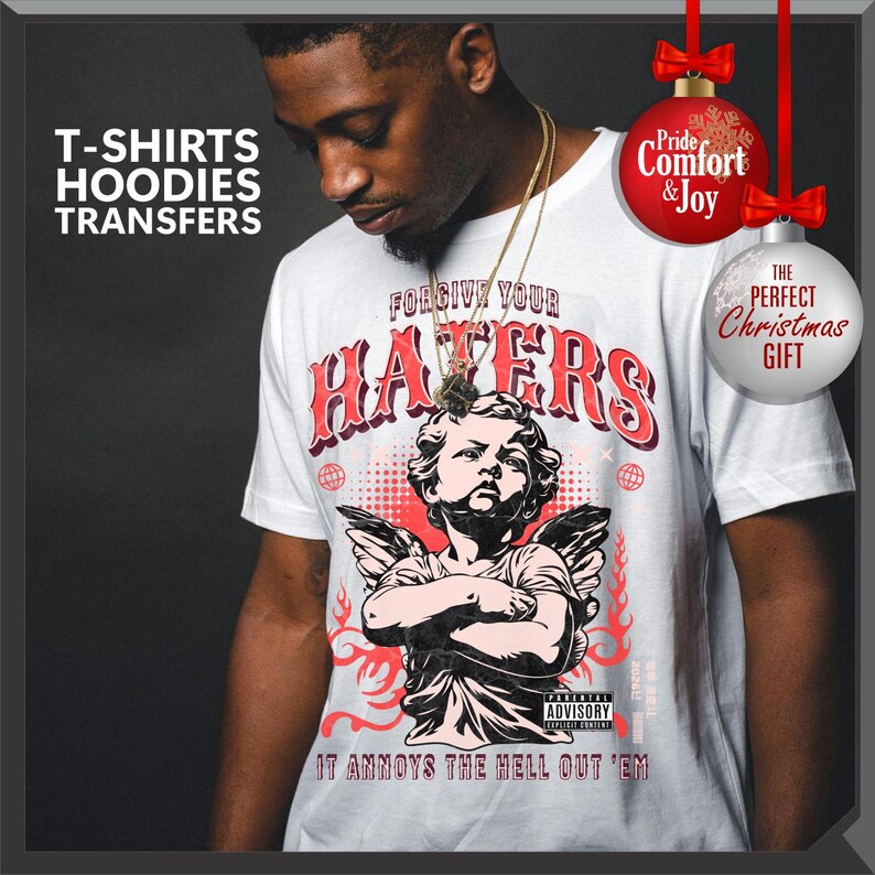 May include: White t-shirt with a graphic of an angel and the text "FORGIVE YOUR HATERS". The shirt also has the text "IT ANNOYS THE HELL OUT 'EM". The image includes text that says "T-SHIRTS, HOODIES, TRANSFERS".