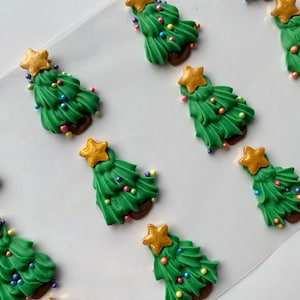 May include: Nine green and gold Christmas tree-shaped sugar decorations with colorful sprinkles.