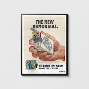 Puede incluir: Póster enmarcado con publicidad de estilo vintage del álbum "The New Abnormal" de The Strokes. La obra muestra una mano sosteniendo un paquete de cigarrillos con el logo de la banda y un disco de vinilo. El texto dice "The New Abnormal."