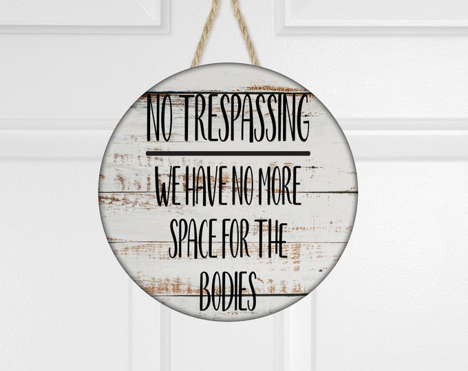 No Trespassing, we have no more room for the  bodies, white washed woodgrain, or blue, round door decor, welcome sign