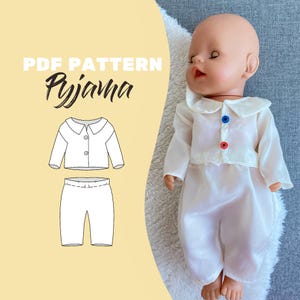 Könnte beinhalten: Eine weiße Puppe trägt einen weißen Pyjama mit einem Bubikragen und drei Knöpfen. Der Pyjama befindet sich auf einer Puppe. Das Bild enthält auch ein PDF-Muster mit dem Wort "Pyjama".