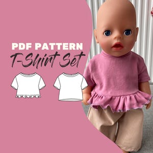 May include: A doll wearing a mauve short-sleeved shirt with a ruffled hem and beige pants. The image includes the text PDF PATTERN T-Shirt Set and two black and white line drawings of the shirt design, one with a ruffle and one without.
