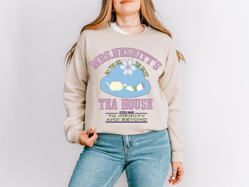 a woman wearing a sweatshirt with a tea house on it