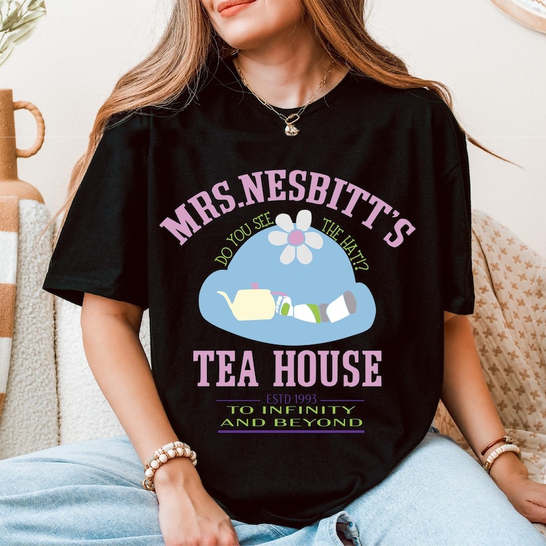 a woman sitting on a couch wearing a black t - shirt