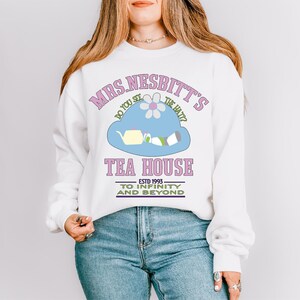 a woman wearing a white sweatshirt and jeans