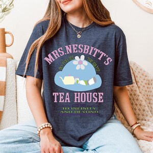 a woman sitting on a couch wearing a blue shirt