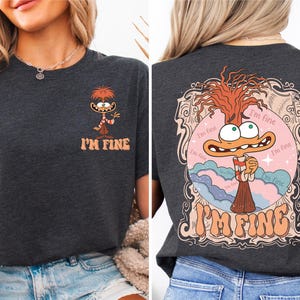 Może przedstawiać: Szary t-shirt z nadrukiem postaci z kreskówki z przodu i z tyłu. Postać to ptak z długą szyją i czerwoną głową. Na koszulce widnieje napis "I'm Fine" z przodu i z tyłu. Postać jest otoczona ramką w stylu vintage z tyłu.